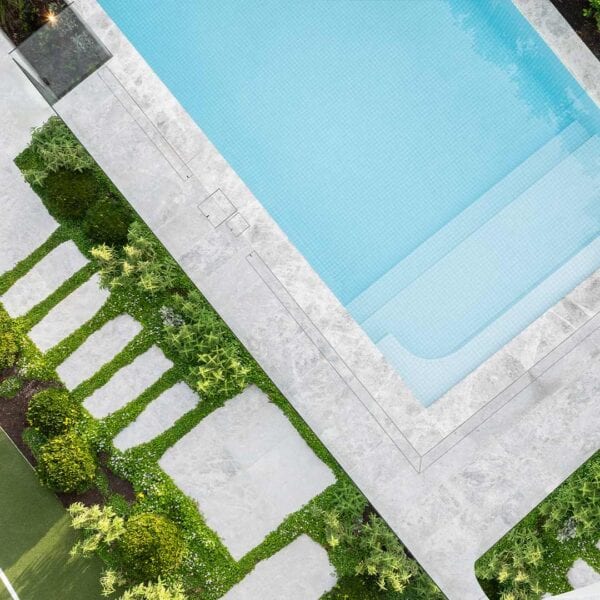HIDE linear drain cover with tile inlay installed in paved pool surround