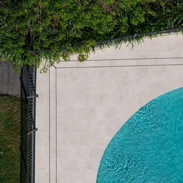 HIDE linear strip drain cover with grey tile inlay installed next to swimming pool