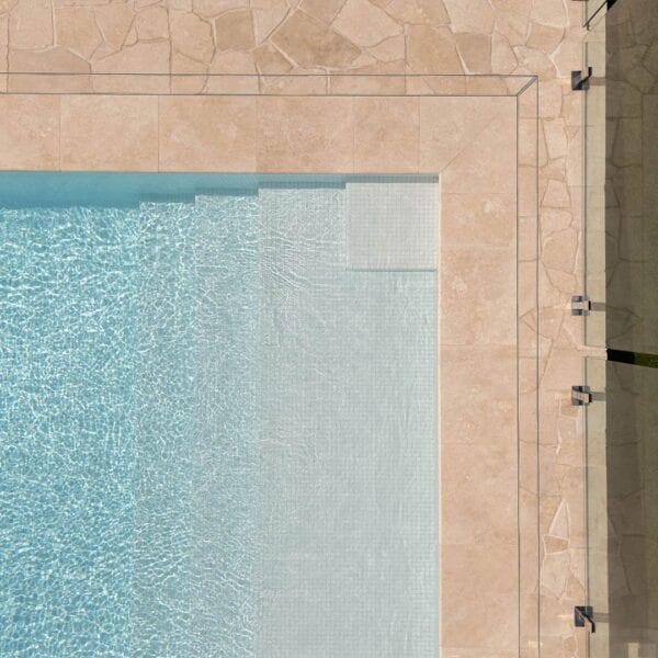 HIDE linear strip drain cover corner with cream crazy pave tile inlay next to pool